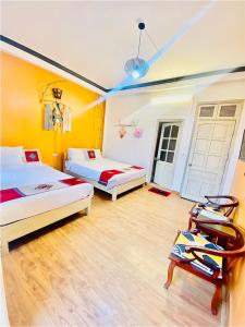 2 Betten in einem Zimmer mit gelben Wänden und Holzböden in der Unterkunft YoLoHome in Sa Pa