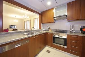 uma cozinha com armários de madeira e electrodomésticos de aço inoxidável em RH- The Perfect Family Getaway, 3BR in Standpoint Tower no Dubai