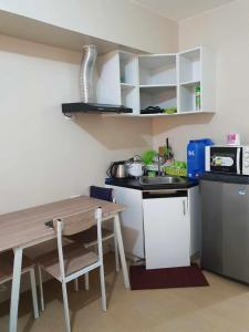 a small kitchen with a table and a microwave at MARIDAN AVIDA CONDO in Iloilo City