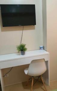a desk with a television on a wall with a chair at MARIDAN AVIDA CONDO in Iloilo City