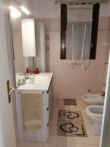 a white bathroom with a sink and a toilet at Casa dal Ganzetto in Rio Marina