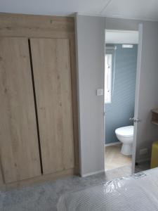 una camera da letto con porte scorrevoli in legno e servizi igienici di Wood Farm Holiday Park a Charmouth