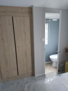 a bedroom with wooden sliding doors and a toilet at Wood Farm Holiday Park in Charmouth +13 photos