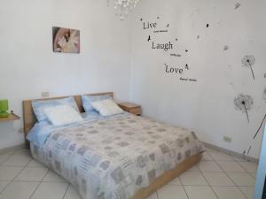 1 dormitorio con 1 cama con palabras en la pared en Casa di mezzo, en Rio Marina