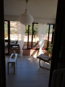 sala de estar con cortinas blancas y mesa en Casa di mezzo, en Rio Marina