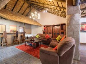 a living room with a couch and a table in a room at Motozi Lodge in Pelindaba