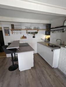 a kitchen with white cabinets and a table and a counter at Monumental gem in the heart of Utrecht City in Utrecht