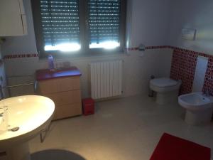 ein Bad mit einem Waschbecken, einem WC und einem Fenster in der Unterkunft B&B Camelie in Melfi