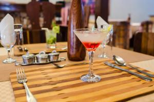 un drink in un bicchiere di Martini su un tavolo di legno di Espace Menamasoandro a Morondava