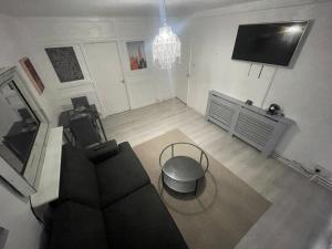 a living room with a couch and a tv at NEW! Xtra Large 4 bedroom Up to 12 guests in Woolwich