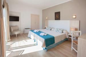 a hotel room with a bed and a chair at Petit Garden Hotel by Flacalco in Cala Ratjada