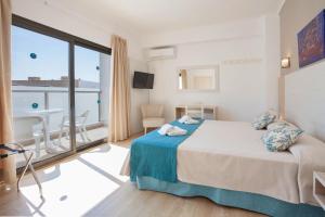 a hotel room with a bed and a balcony at Petit Garden Hotel by Flacalco in Cala Ratjada
