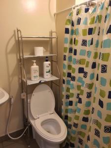 a bathroom with a toilet and a shower curtain at MARIDAN AVIDA CONDO in Iloilo City