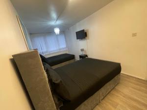 a small bedroom with a bed and a couch at NEW! Xtra Large 4 bedroom Up to 12 guests in Woolwich