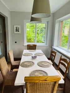 uma sala de jantar com uma mesa branca e cadeiras em Vīnkalni em Plieņciems