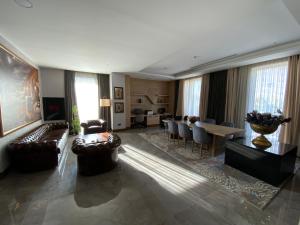 uma sala de estar com sofás, uma mesa e cadeiras em Ramada by Wyndham Adiyaman em Adıyaman