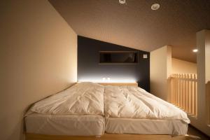 a bedroom with a white bed with a tv on the wall at Private Villa ietona in Fujikawaguchiko