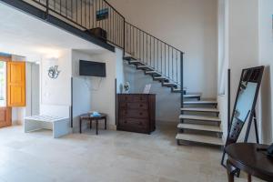 un salon avec un escalier et une télévision dans l'établissement Borgo Vita Novella, à Marzamemi