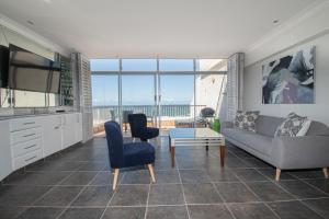 a living room with a couch and chairs and a television at 21 Bronze Bay Umhlanga Rocks in Durban