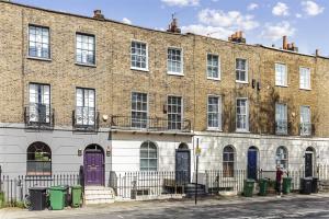 a large brick building with purple doors on a street at Camden Town Apartment in London