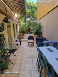 un patio al aire libre con mesas, sillas y una mesa en Gîte Maison provençale entre Aix et Marseille, en Gardanne
