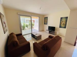 City Center Villa 7ms to Mall & Beach في بافوس: غرفة معيشة بها كنب بني وتلفزيون