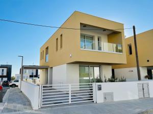 ein Haus mit einem weißen Zaun davor in der Unterkunft City Center Villa 7ms to Mall & Beach in Paphos City