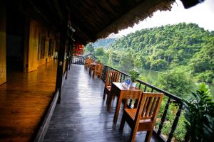 un restaurante con mesas y sillas en un balcón en Ba Be Jungle Houses, en Ba Be18