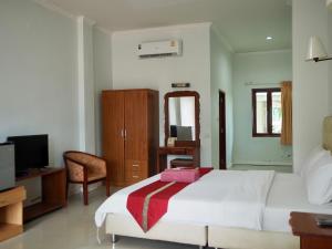 a bedroom with a bed and a desk and a television at Onthebeach resort in Ban Hin Sam Kon