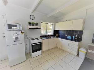 a kitchen with a white refrigerator and a stove at Three Palms Apartments Unit 1 in Esperance