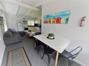 a kitchen and a living room with a table and chairs at Three Palms Apartments Unit 1 in Esperance