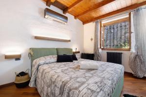 ein Schlafzimmer mit einem Bett und einem großen Fenster in der Unterkunft Farmhouse of Grandfather Chek in Bellagio