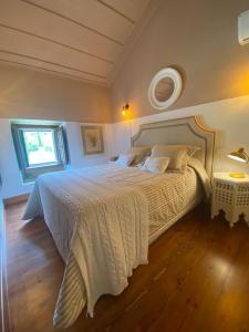 1 dormitorio con 1 cama grande con colcha blanca en Quinta dos Pegões en Tomar
