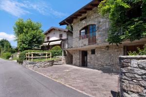 uma casa de pedra com uma varanda ao lado em Farmhouse of Grandfather Chek em Bellagio