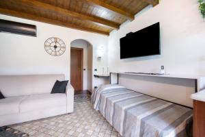 ein Wohnzimmer mit einem Sofa und einem Flachbild-TV in der Unterkunft Farmhouse of Grandfather Chek in Bellagio