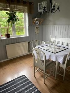 a dining room with a white table and chairs at Centralt boende i Charlottenberg och nära till Valfjället Skicenter handdukar och sängkläder ingår Städning ingår inte in Charlottenberg