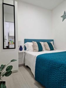 ein Schlafzimmer mit einem blauen Bett und einem Spiegel in der Unterkunft Merluza in Nazaré