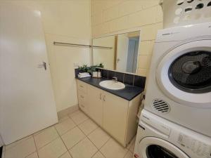 a bathroom with a washing machine and a sink at Esperance Little Units 2 in Esperance +7 photos