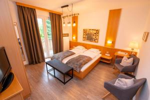 pokój hotelowy z łóżkiem i 2 krzesłami w obiekcie Arlbergerhof Vital w mieście Weissensee