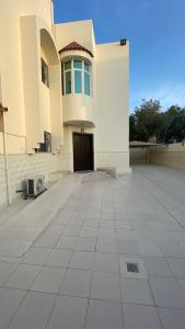 a large white building with a door and a courtyard at H5-hاتش5 in Madīnat Yanbu‘ aş Şinā‘īyah