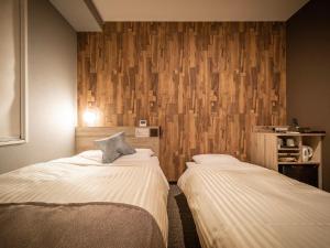 Ένα ή περισσότερα κρεβάτια σε δωμάτιο στο Super Hotel Premier Namba Shinsaibashi Natural Hot Spring