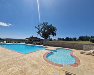 a swimming pool in a yard with a stone wall at Agriturismo Le Querce in Bomarzo