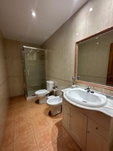a bathroom with a sink and a toilet and a shower at APARTAMENTOS MAR DE AREAS in Sanxenxo