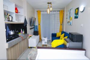 a small living room with a yellow and blue couch at Superb Studio Apartment in Nairobi
