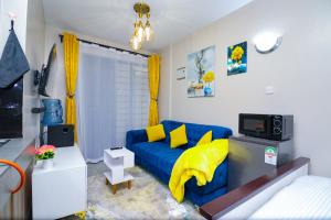 a living room with a blue couch and yellow pillows at Superb Studio Apartment in Nairobi