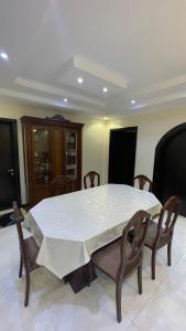 a dining room table with a white table cloth on it at H5-hاتش5 in Madīnat Yanbu‘ aş Şinā‘īyah