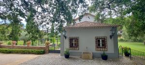 a white house with two windows and a fence at Casa da Vinha - Quinta dos Pegões in Tomar
