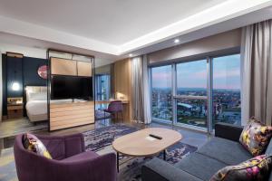 a living room with a couch and a room with a view at Doubletree By Hilton Afyonkarahisar in Afyon