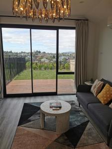 uma sala de estar com um sofá e uma mesa em Paradise Retreat em Tauranga