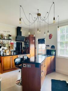 uma cozinha com armários de madeira e um balcão preto em Grade II boho home in the heart of Oxford St. em Southampton